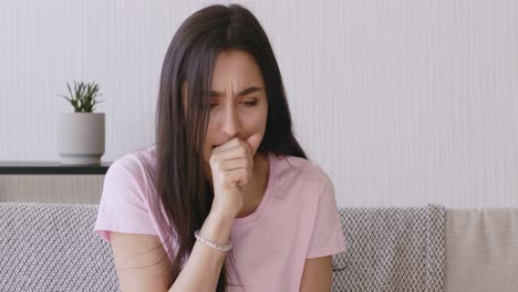 mujer tosendo en un sofá