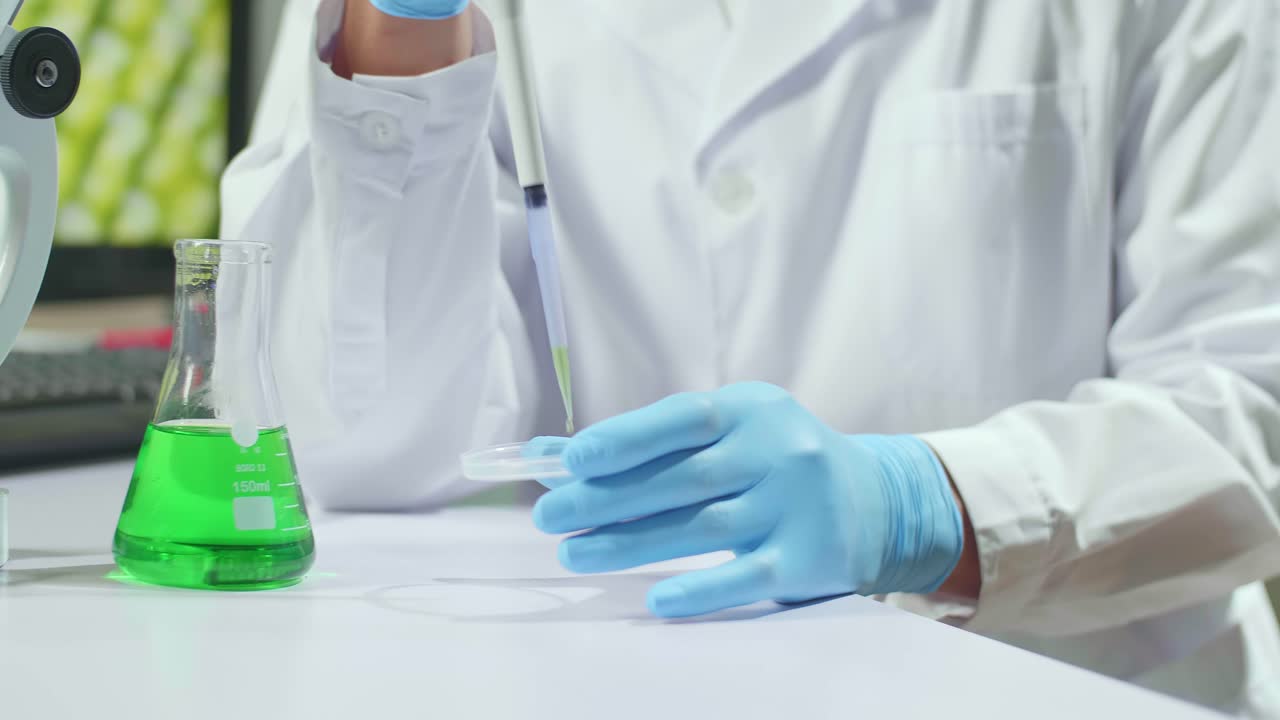 Closeup Of Botanist Reseacher Man Taking Dna Liquid Test From Medical Glass Putting On Petri Dish. Scientist Examining Agriculture In Botanical Lab