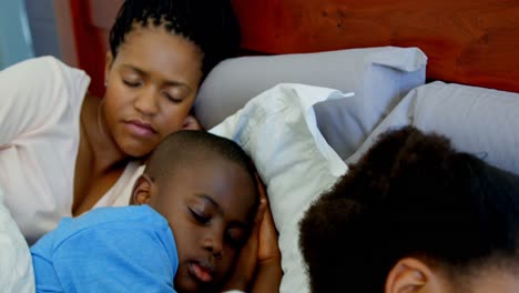 Vista-Frontal-De-Una-Joven-Familia-Negra-Durmiendo-Juntos-En-La-Cama-En-El-Dormitorio-De-Una-Cómoda-Casa-4k