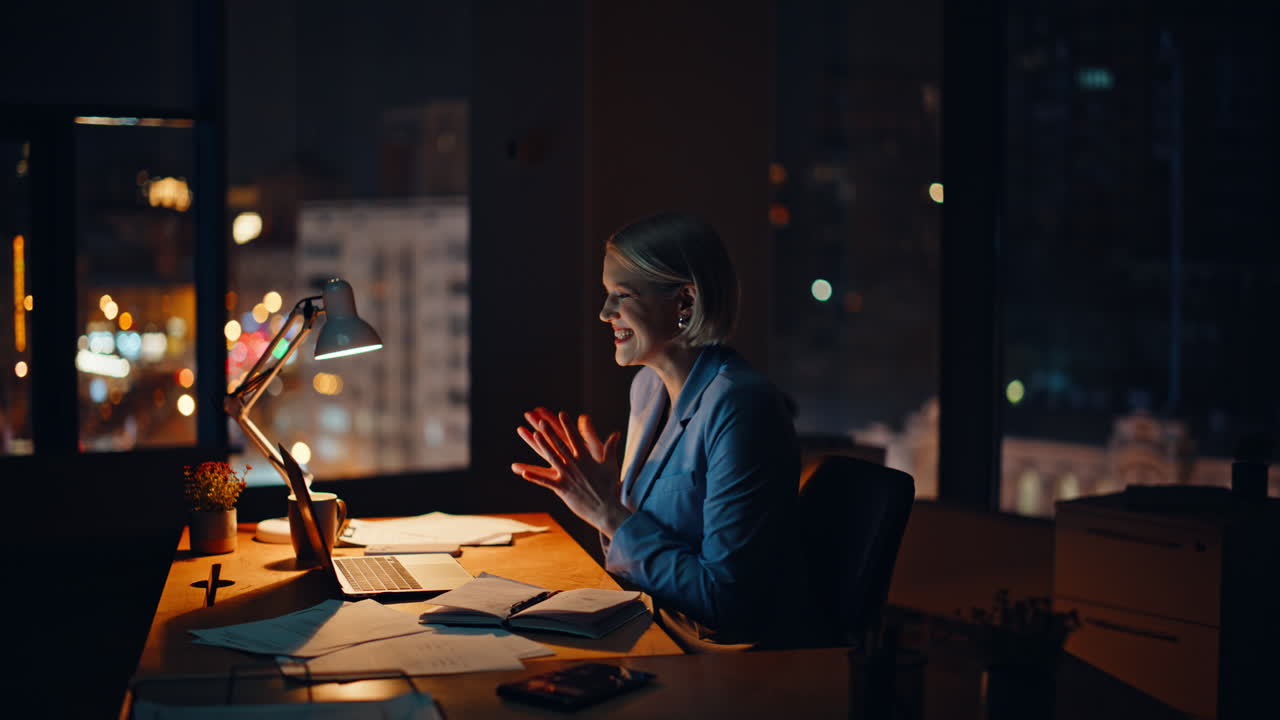 Overjoyed broker looking laptop reading great news rejoicing at night workplace