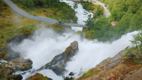 el viajero admira el tormentoso río de montaña que se origina en el glaciar briksdal la majestuosa escena