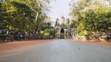First person view riding a motorcycle leaving through Victory Gate, Angkor Wat Thom Cambodia