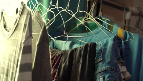 a mix of casual shirts and denim neatly arranged on wire hangers in soft sunlight—perfect for home, laundry, or lifestyle edits