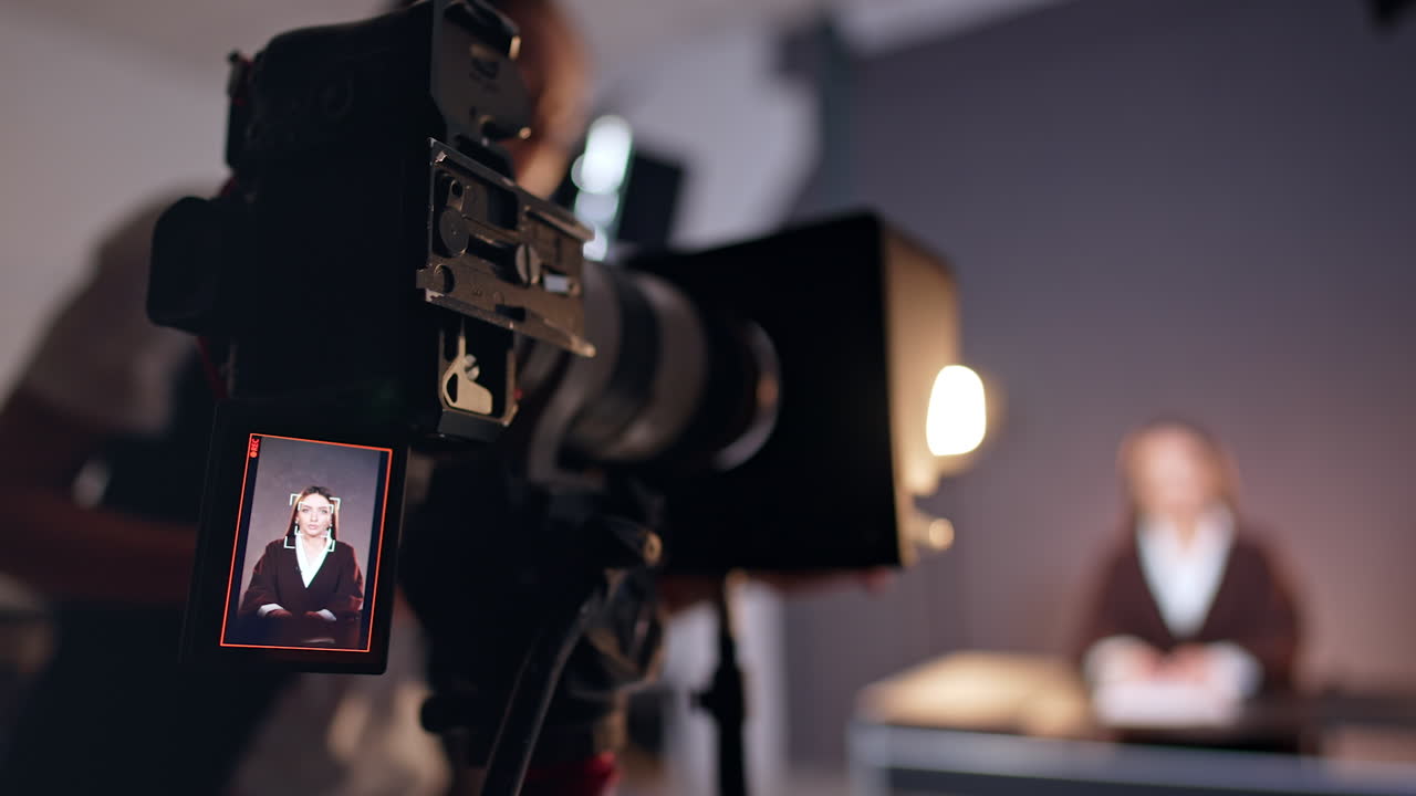 Brunette Caucasian lady on the display of modern camera. Close up. Unrecognized woman stands near the camera fixing equipment. Blurred backdrop