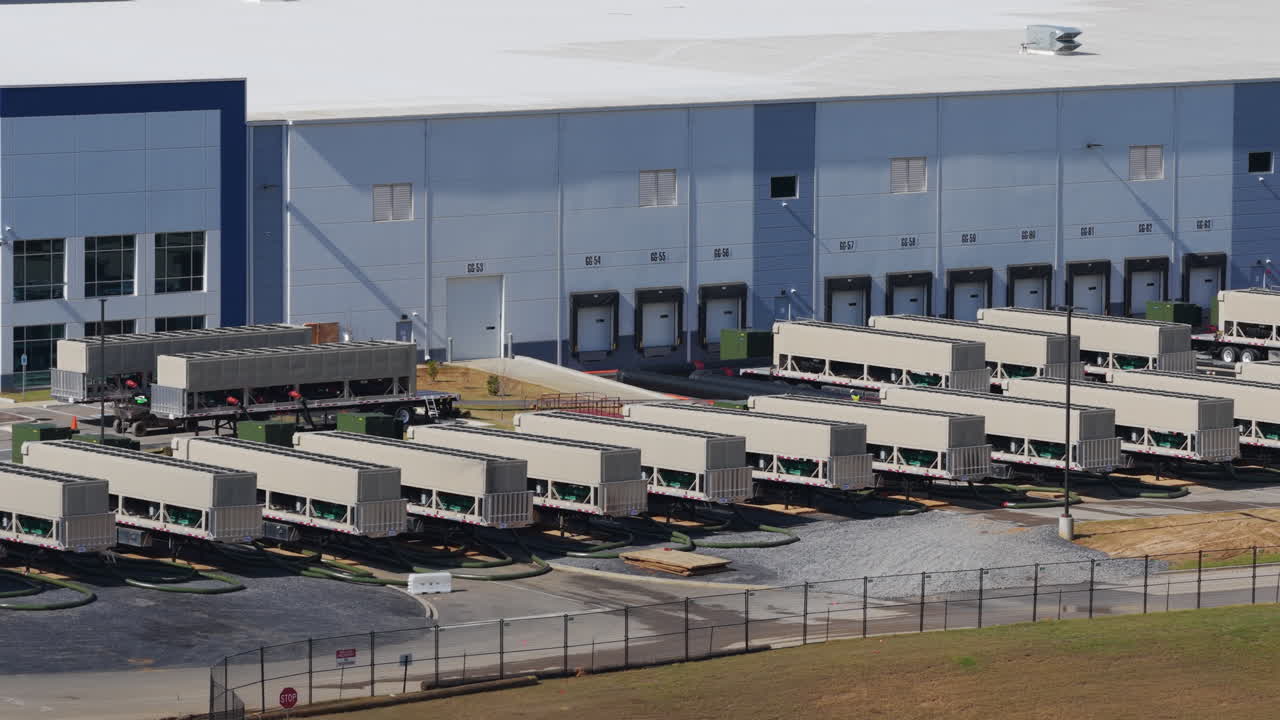 Large Industrial Facility With Rows Of Trailers Docked At Loading Bays In Southaven, Mississippi. - aerial shot