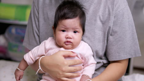 a baby girl who was just born a few months ago is wriggling in her mother's arms