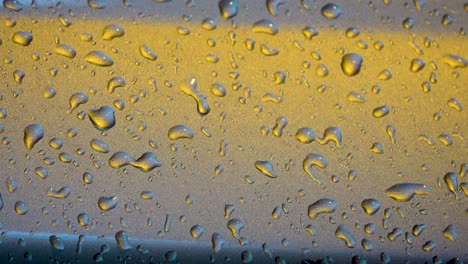 Gotas-De-Agua-Sobre-Una-Superficie-Metálica-En-Tonos-Naranja-Verde-Azulado-Durante-La-Lluvia