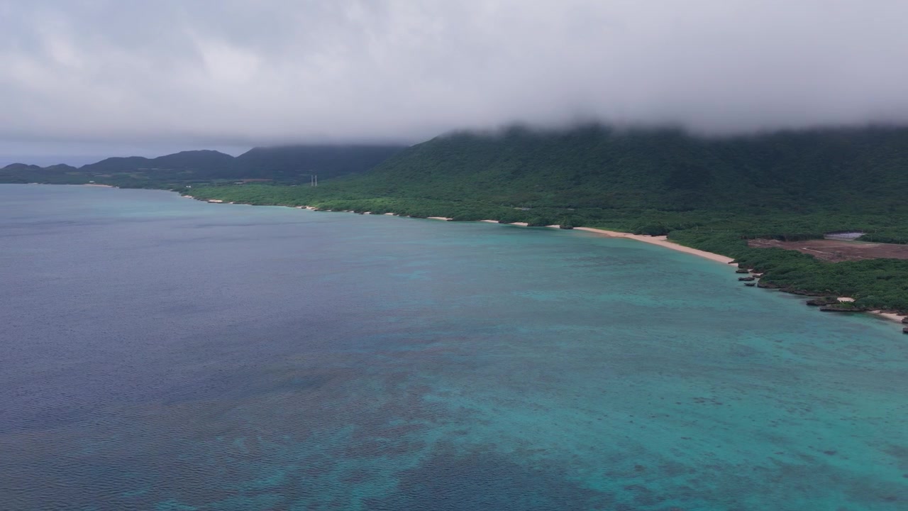 Riprese aeree orizzontali con movimento a destra e panoramica a sinistra lungo la costa turchese di Nosokoniaru Beach e Ibaruma Bay, Isola di Ishigaki, Okinawa, Giappone