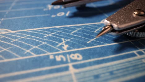 close-up of a blueprint with drafting compass