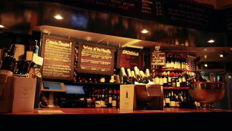 bar counter with wine bottles and menu signs