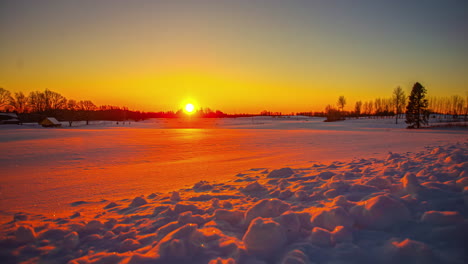 Wunderschöner-Sonnenaufgang-über-Einer-Winterlandschaft-Mit-Orangen-Und-Roten-Farben,-Die-Sich-Im-Weißen-Schnee-Auf-Den-Feldern-Spiegeln