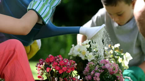 close up on a cute girl is watering flowers in front of her family