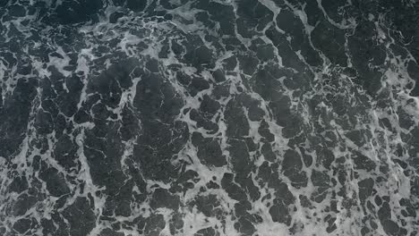 overhead shot of ocean waves with patterns and textured background in the shallow waters of looc bay, philippines