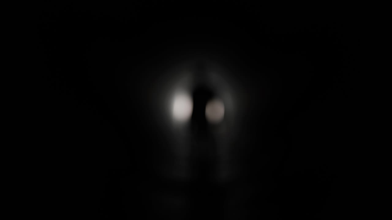 Silueta de hombre caminando hacia la luz en un túnel oscuro.