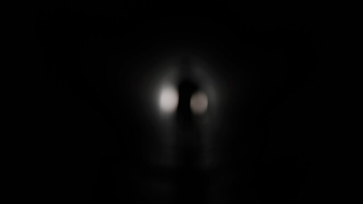 Silhouette di un uomo che cammina verso la luce in un tunnel buio.