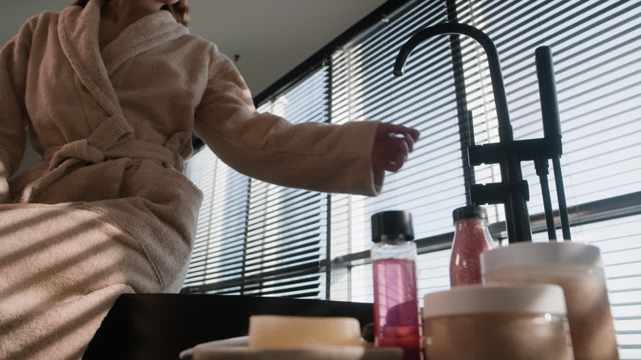 Woman in bathrobe preparing spa products