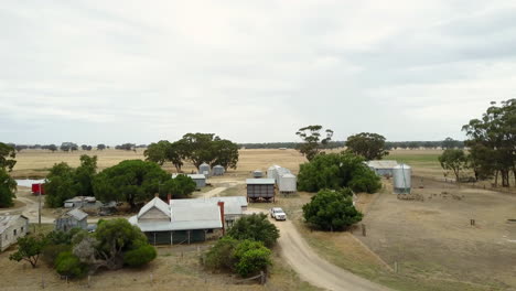 Nostalgia-on-a-oil-farmhouse-field-,-with-a-pickup-truck-passing-on-a-rough-pathway-on-the-Australian-country-side