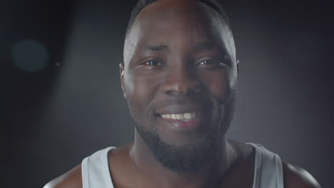 Portrait-of-Smiling-Black-Man-against-Dark-Background