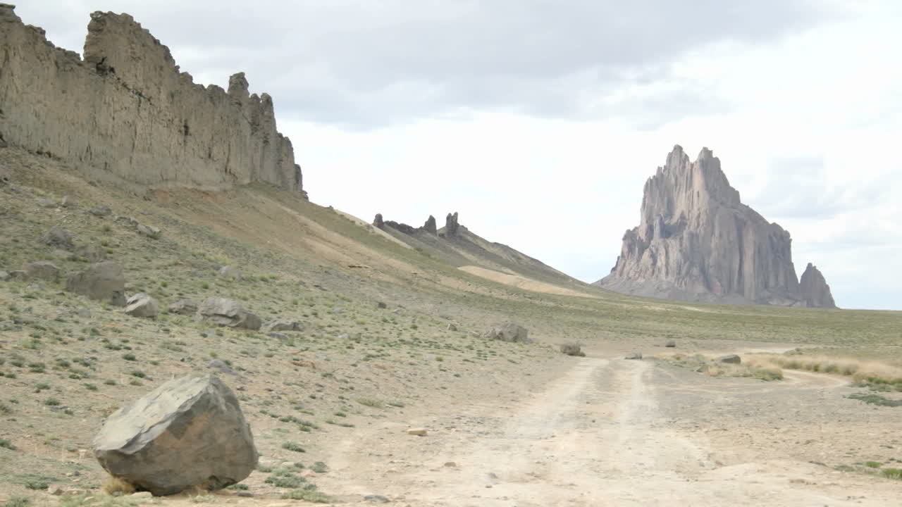 un camino de tierra conduce al monumento shiprock