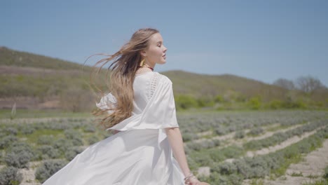 woman in white dress walking in lavender field