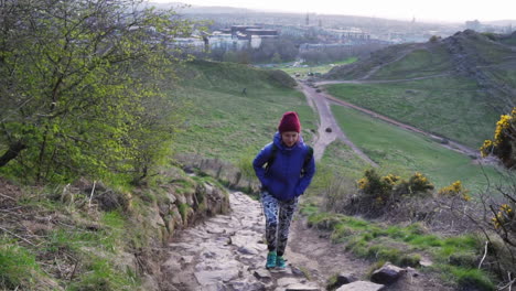 slowmo of attractive girl hiking to arthur's seat, edinburgh, scotland