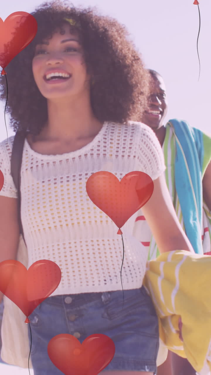 animación de corazones sobre una feliz pareja afroamericana en la playa