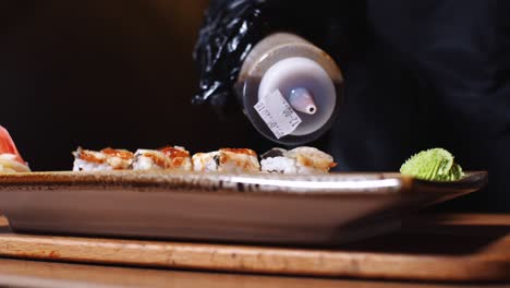 el chef está preparando sushi de salmón teriyaki.
