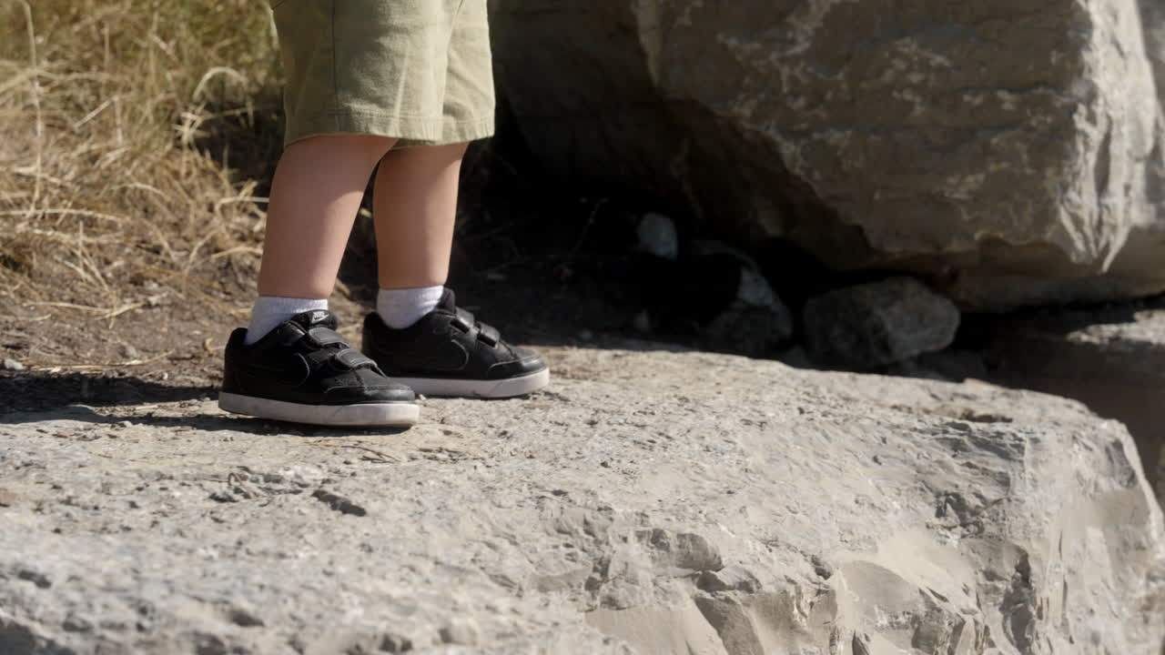 un niño aventurero caminando sobre grandes rocas