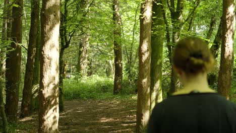 Woman-Walking-Along-Forest-Trail-Path-Enjoying-Relaxing-Nature-Hike