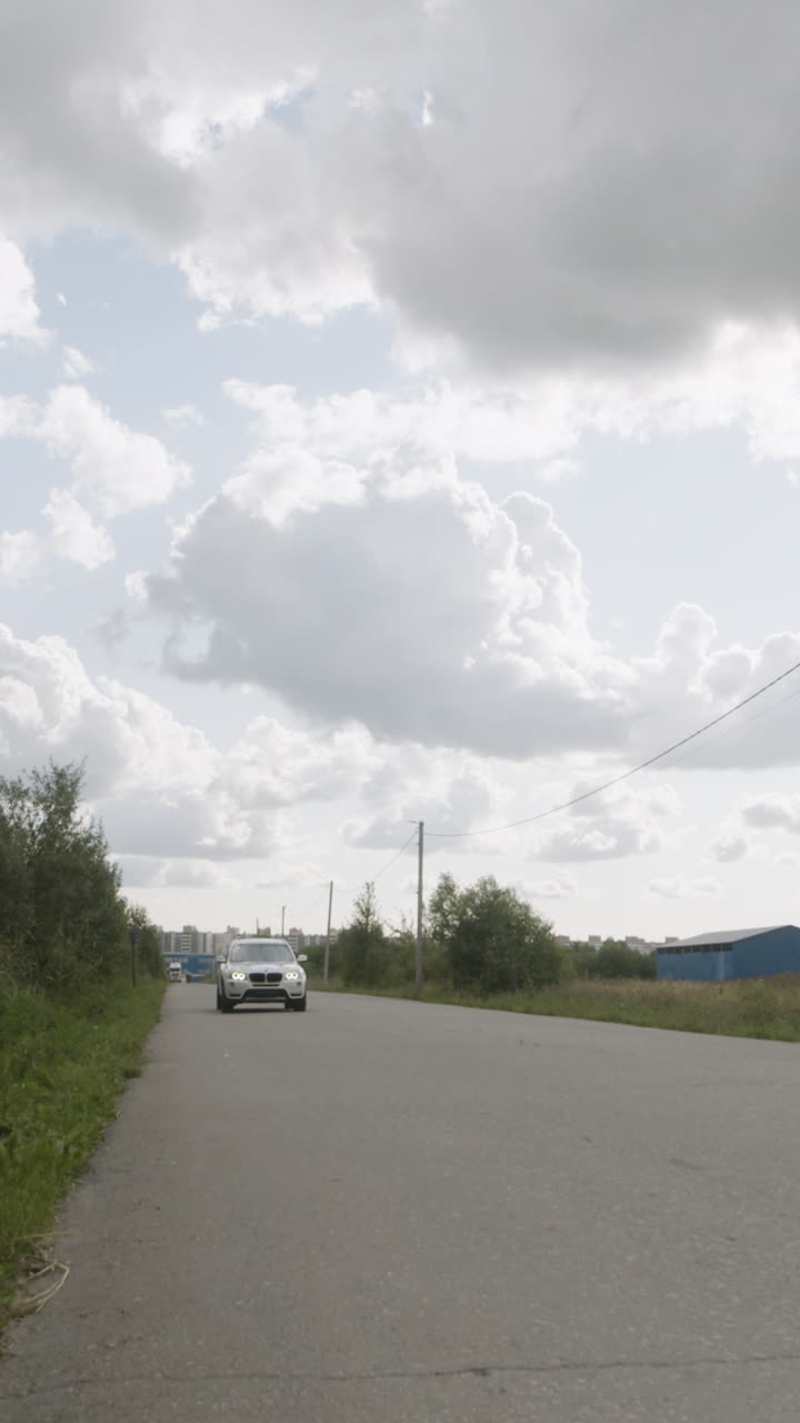 Car driving on a road under a cloudy sky