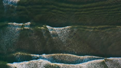 Golden Hour Aerial of Waves Crashing Softly, with the Drone Flying Along Their Path From Above