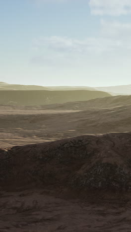 a barren desert landscape on mars, with red sand, rocky terrain, and a clear sky with clouds.