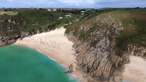 Aufsteigende-Drohnenaufnahme-Des-Strandes-Von-Porthcurno-Und-Der-Umliegenden-Bucht