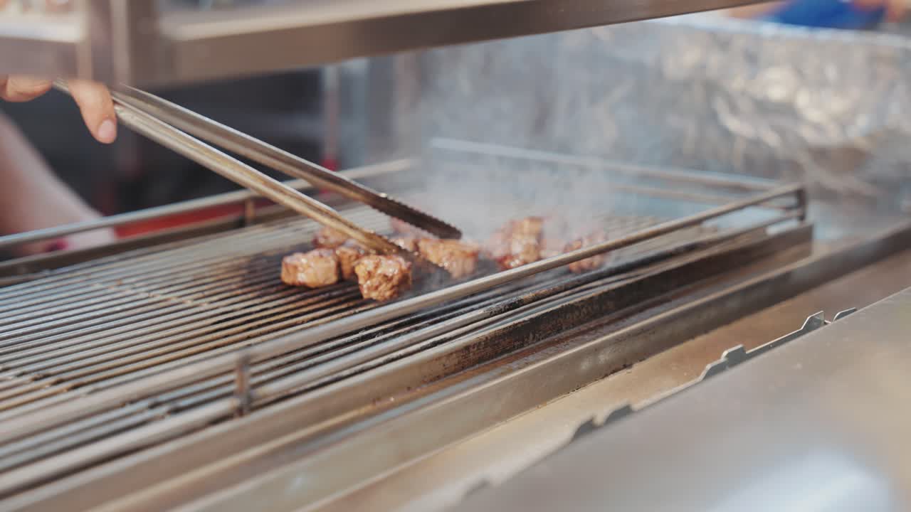 A Taiwanese street food vendor expertly flame-torching juicy beef cubes, capturing the fiery preparation and mouthwatering appeal of this popular night market delicacy