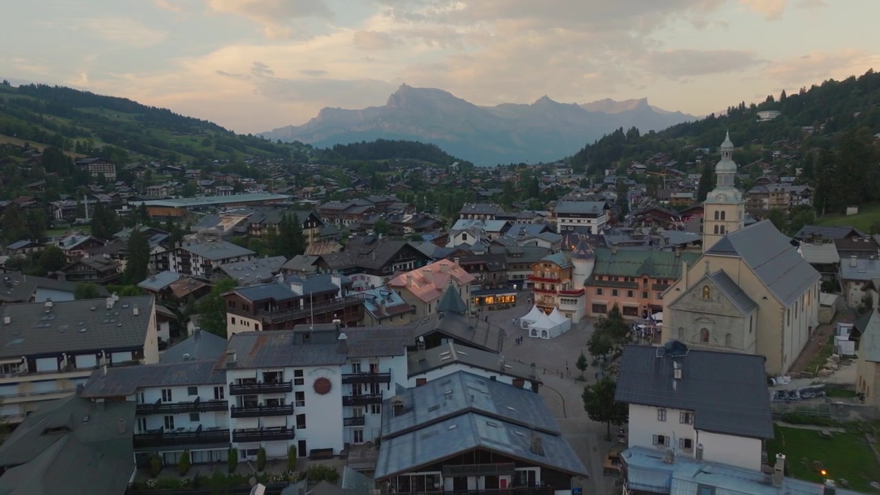 Luftaufnahmen mit Drohne von Megève, Frankreich, umgeben von den atemberaubenden französischen Alpen. Filmische Berglandschaften mit alpinen Wäldern, traditionellen Chalets, sanften Hügeln und spektakulären Panoramablicken.