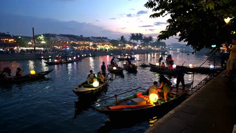 boatmen and boat ladies take tourists and visitors on an evening tour of thu bon river at a section of the old quarter in the city of hoi an, vietnam.