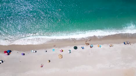 Overhead-Dröhnen-Von-Sonnenschirmen-An-Einem-Sandstrand-Und-In-Der-Nähe-Der-Wellen