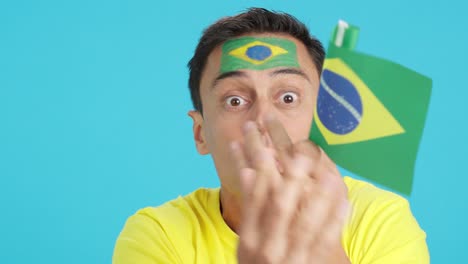man with brazilian national flag upset with a football referee
