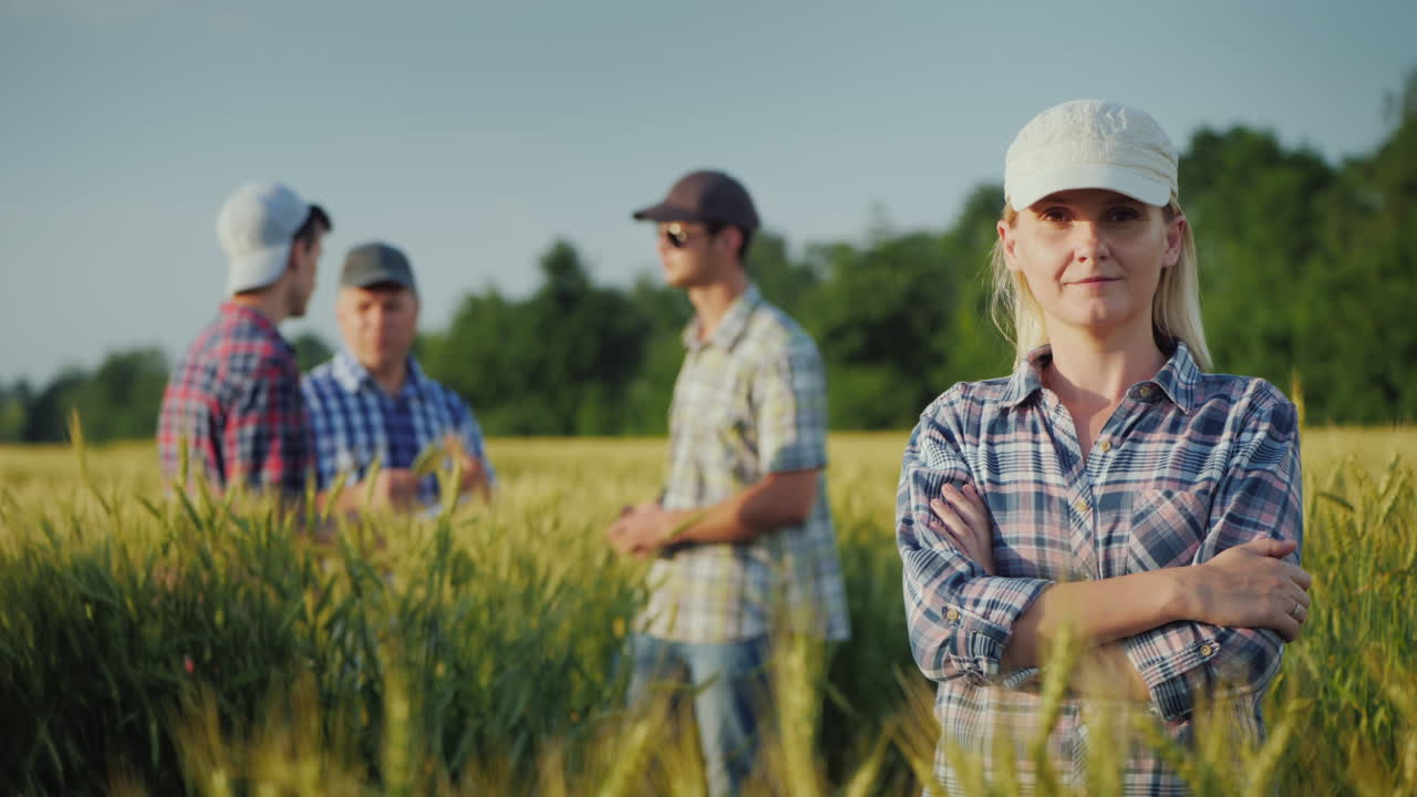 들판 배경에 있는 젊은 여성 농부의 초상화와 의사소통을 하는 다른 농부들