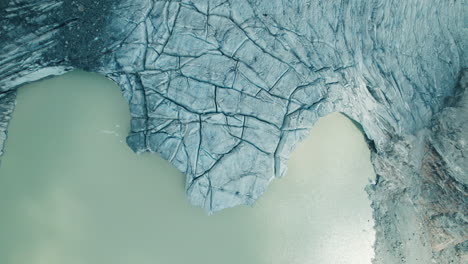 glacier melting in a lake below due to climate change in the alps, view from above