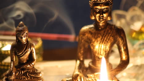 buddha statues meditating with candles close up 08