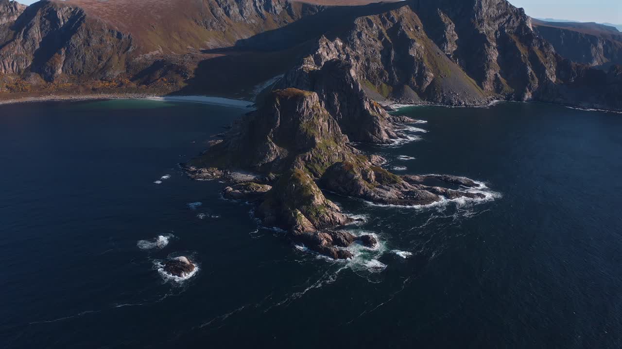 Dramatic coastal cliffs, isolated island formations, and the ocean at vestarelen, aerial view