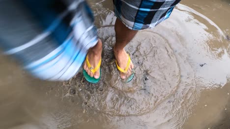 Man-In-Slippers-Marching-In-Place-On-A-Muddy-Water-With-Water-Splashes