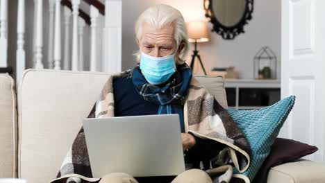 portrait of sick man wearing a surgical mask and sitting in the living room