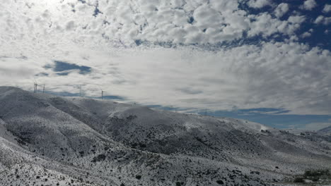 montañas cubiertas de nieve fresca con nubes en el cielo, retroceso aéreo