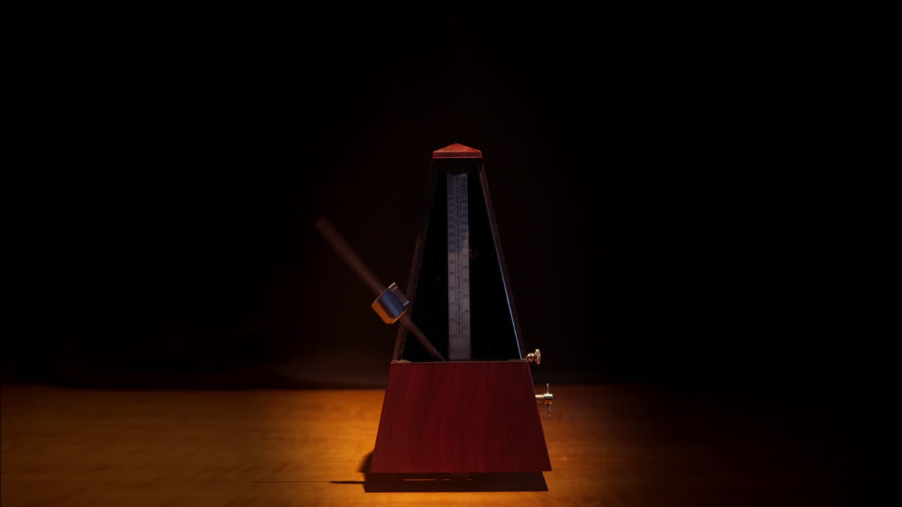 Wooden Metronome Swinging Pendulum in Dark Room