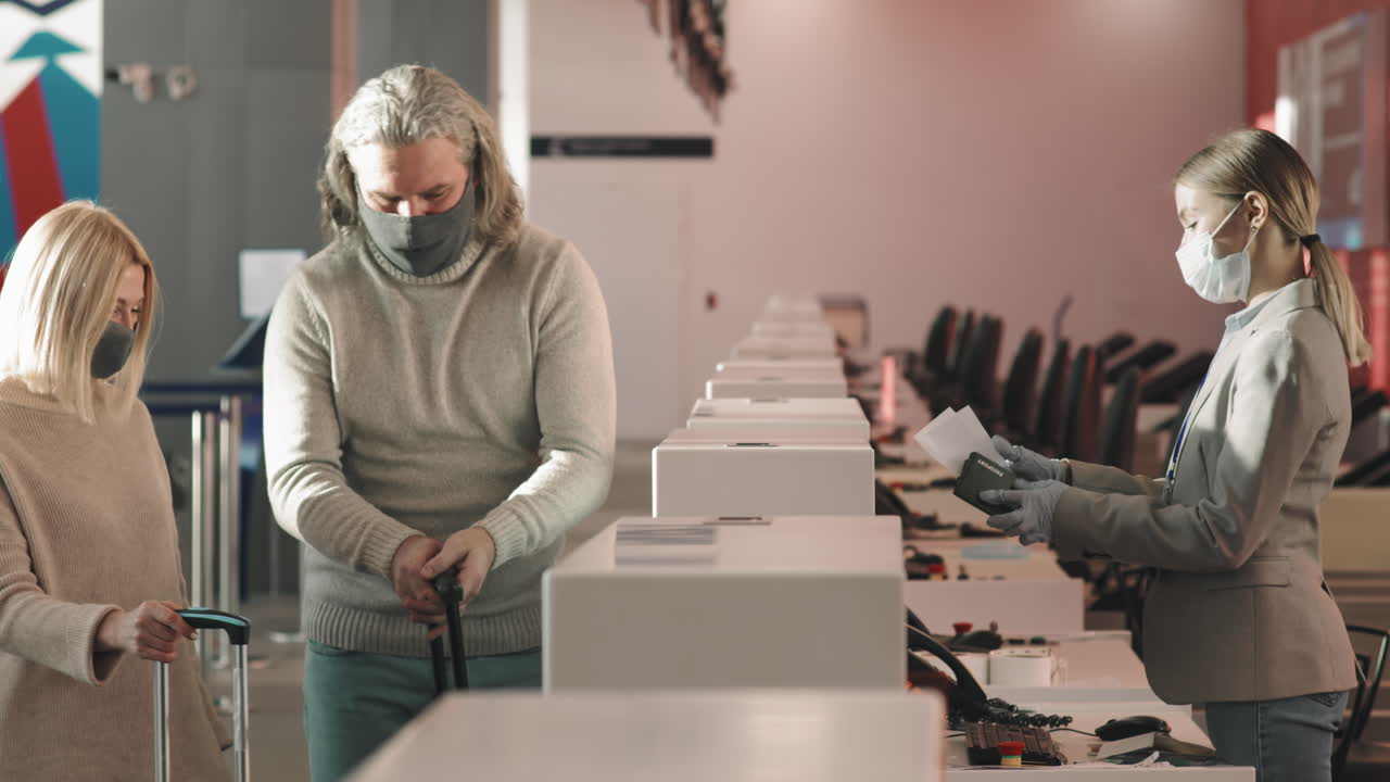 Adult Couple Checking-In At Airport