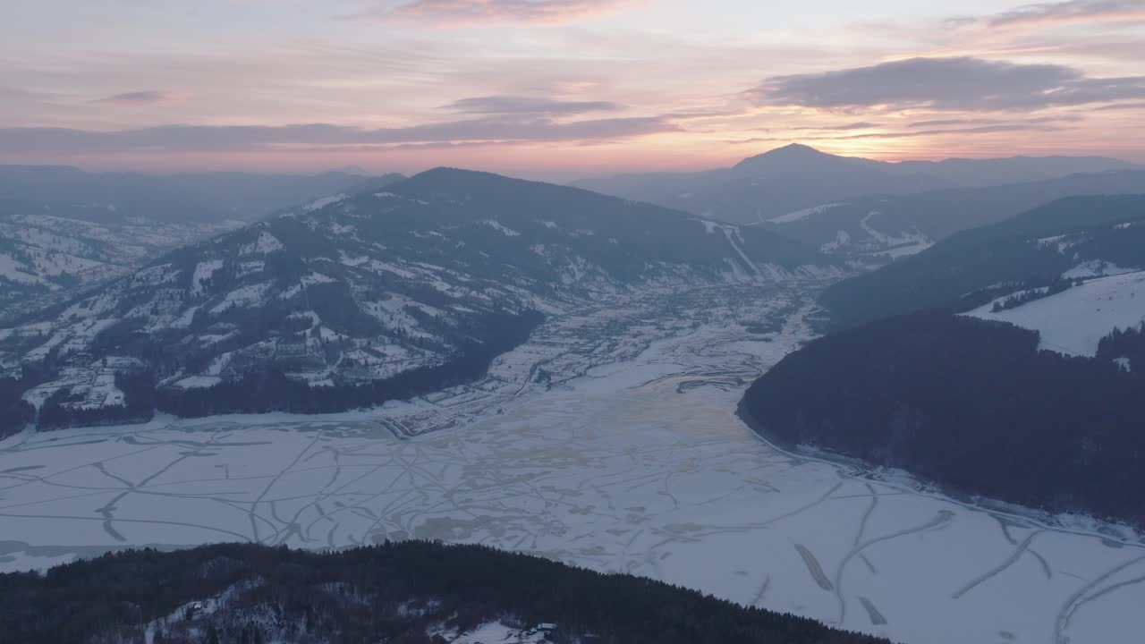 Winter landscape with snow covered mountains at sunset