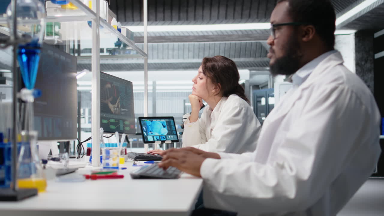 Vertical video Laboratory manager oversees scientists working on computer