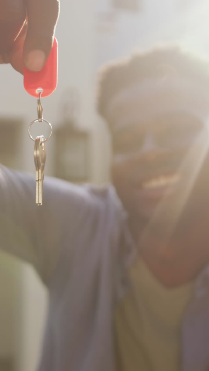 video de una feliz pareja afroamericana abrazándose y mostrando las llaves de una nueva casa
